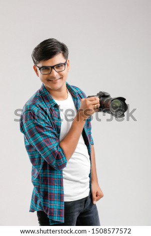 Young Indian man capturing photo with camera