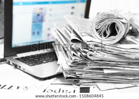 Newspapers and Laptop. Different Concepts for News - Social Network or Traditional Tabloid Journals. Data Sources - Electronic Screen of Computer or Paper Pages of Magazines, Internet or Papers       
