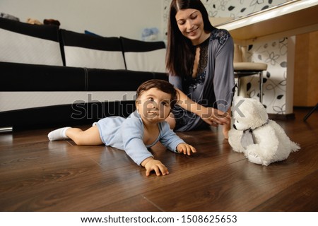Mother playing with teddy bear and her baby son indoor flat - Asian mixed ethnicity child Boy wearing blue body shirt with smiling bear cartoon Pregnant