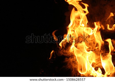 Burning flames of violent movements in the wind at night, black background