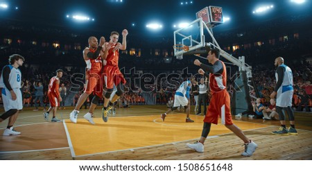 Basketball players on big professional arena during the game. Tense moment of the game. Celebration