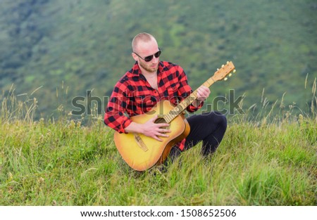 In unison with nature. Keep calm and play guitar. Man with guitar on top of mountain. Acoustic music. Music for soul. Playing music. Sound of freedom. Musician hiker find inspiration in mountains.