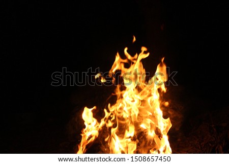 A flame that burns in the middle of a knife on a black background