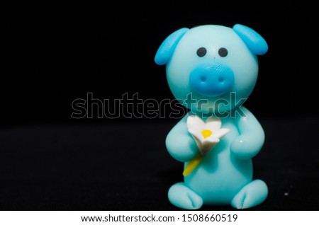 small sculpture blue pig. in picture blurred background and foreground the obvious.