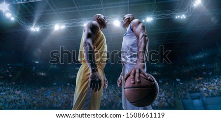 Two black basketball players on big professional arena before the game. Two teams. Players collided face to face. Player holds a ball.