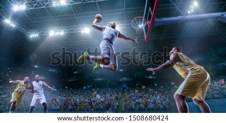 Basketball players on big professional arena during the game. Basketball player makes slam dunk. Bottom view