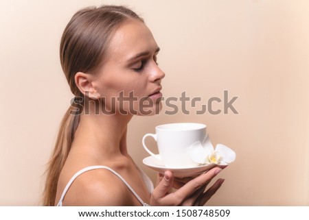 Young woman enjoying a cup of coffee. Portrait of female with morning tea. Copy space