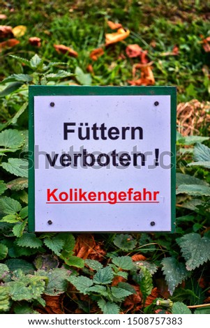 Shield with warning. - Letters with Füttern verboten! Kolikengefahr Means Feeding prohibited! colic risk