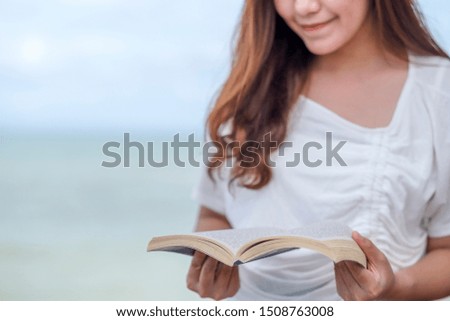 A beautiful asian woman reading book by the sea