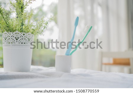 The toothbrushes in a ceramic cup with copy space in bathroom