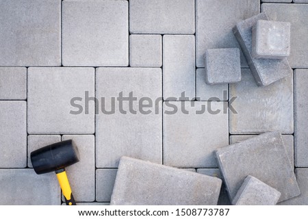 Paving stones paving background. Installing tools on foreground