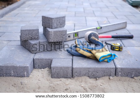 Paving stones pathway paving background. Installing tools on foreground