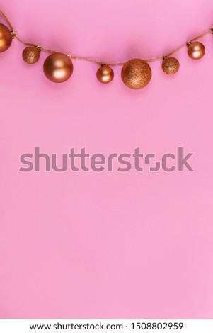 Small and large gold-colored Christmas balls with sparkles on a rope. Christmas decor, design for greeting card or advertising sign. Top view, copy space, holiday concept.