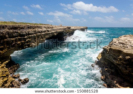 Waves Crashing on Rocks at Devil's Bridge Antigua in Sunshine Royalty-Free Stock Photo #150881528