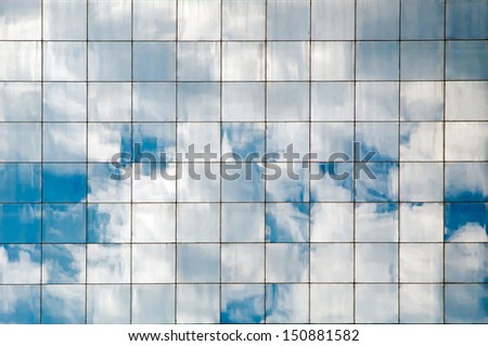 Clouds reflected in windows of modern office building 