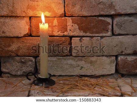 Single burning candle on the brick background in night 2