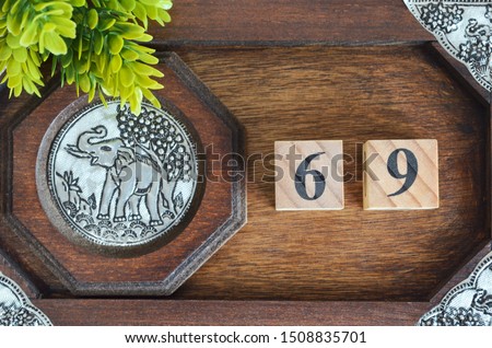 Number 69, Number cube with elephant silver wooden design for background. room number.