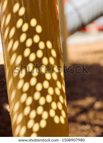 Sunlight Shining Through Holes onto a Pole.