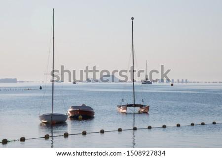 Backlit view of boats and sailboats in the Manga del Mar Menor, early morning in Murcia, Spain