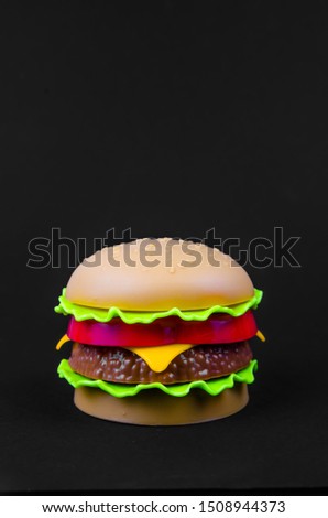 fast food. plastic hamburger on a black background