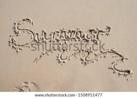 inscription "Summer" written on the sand on the shores of the sea. 