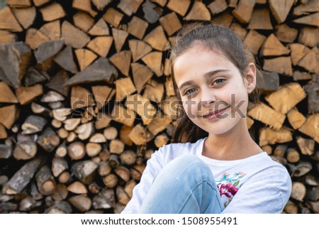 Close up portrait of beautiful cute brunette girl with healthy skin that smiling and looking at the camera isolated over firewood background, summer holidays