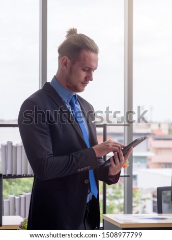 Caucasian businessman using tablet in the modern workplace to communicate or deal the business online. Business and Technology concept