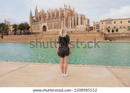 Cathedral La Seu at Palma de Mallorca with tourist, young blond woman looking towards it. Mallorca island, Spain Royalty-Free Stock Photo #1508985512