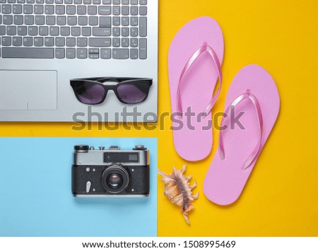 Summer leisure. Summertime relax.Laptop and travel accessories on yellow background. Studio short. Beach object. Top view. Flat lay