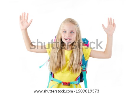 Enthusiastic elementary school girl posing with arms raised up, victorious. Isolated on white background