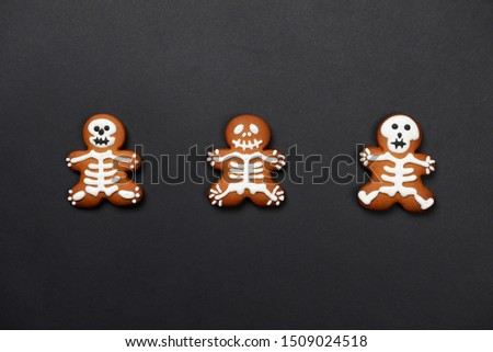 The hand-made eatable gingerbread Halloween sceletons on black background