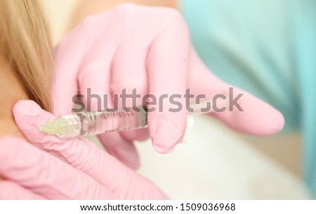 Women is injecting. Closeup Of Beautician Doctor Hands Doing Beauty Procedure. Woman face wrinkles procedures, anti-aging stock photo. Relax face muscles, it is almost never too early to start