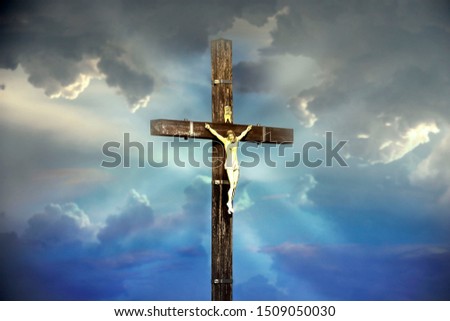 Jesus Christ on the cross against the blue sky background. Crucifixion of Jesus. Christian religion symbol.