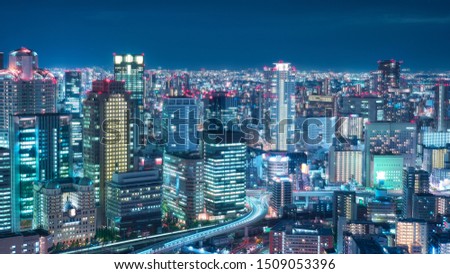 Aerial night view of Osaka city - Asia business city concept image, panoramic modern metropolis bird’s eye view at evening, shot in Umeda Sky Building observatory, Osaka, Japan. Double exposure image.