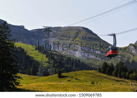 Red cable car going up a mountain