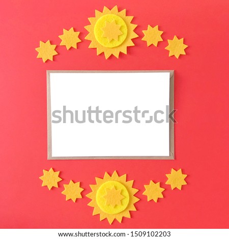 Blank postcard with brown craft paper envelope on red background, composition with sunny yellow felt stars for stationery mock ups, postcards, letters, greeting cards, prints, invitations, flyers.