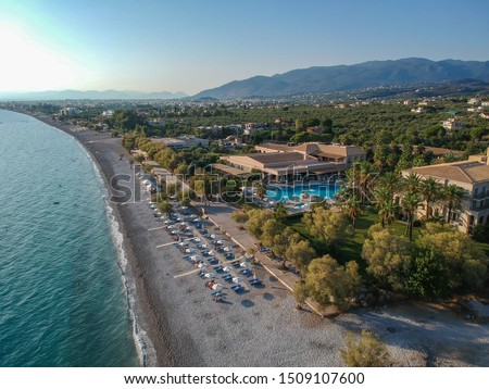 Aerial paraglider view over the beautiful seaside city of Kalamata, Greece.  Famous organised beach with sun beds and umbrellas a beautiful hotels - resorts during Summer period in Kalamata, Messenia.