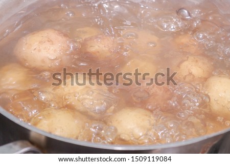 New potatoes boil in their skins in a saucepan