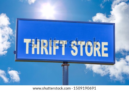 Thrift store sign against a blue sky with clouds and sunshine 