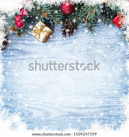 Christmas fir tree branches with toys on old wooden table with bokeh light. Beautiful Christmas background.