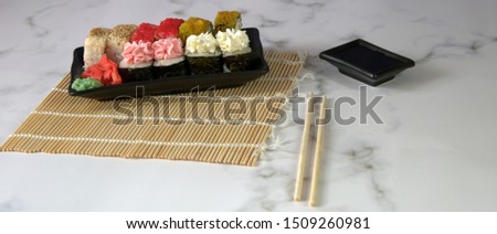 Sushi set with soy sauce, wasabi and ginger on a bamboo napkin. Close-up.