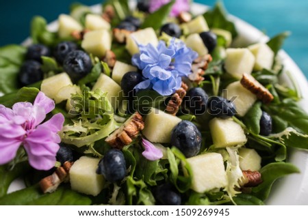 Salad with comestible flowers and grapes. Royalty-Free Stock Photo #1509269945
