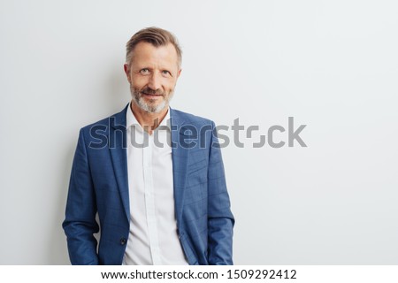 Thoughtful businessman scrutinising the camera with a serious pensive expression against a white studio background with copy space