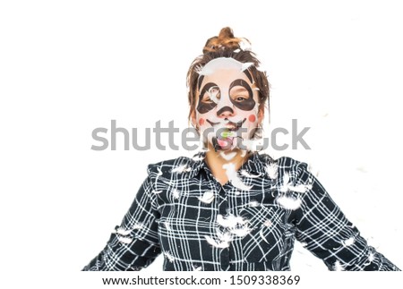 Young teenage girl with facial panda mask looking at camera isolated on white background. Cosmetic procedure. Beauty spa and cosmetology.