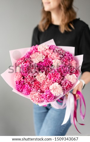 Mono bouquet. Bunch of carnation flowers rich pink color. Spring bunch in woman hand. Present for Mothers Day.
