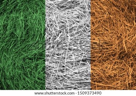 Ireland flag on a hay roll surface. Textured wallpaper background for creativity and design.
