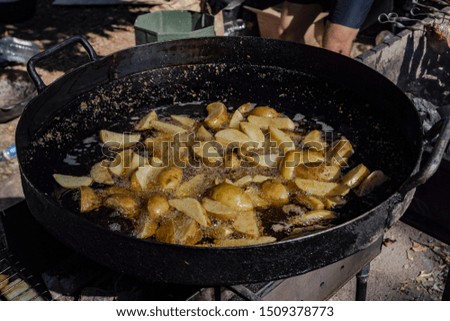 Cooking a rustic breakfast - large pieces of potatoes are fried in a pan stock photo