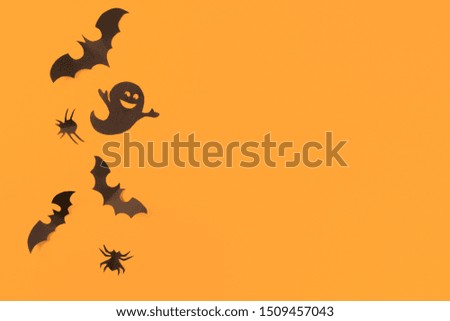Halloween paper decorations on orange background. Halloween concept. Flat lay, top view, copy space
