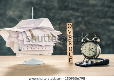 overdue concept with stack of unpaid bills ,calculator and clock on table Royalty-Free Stock Photo #1509506798