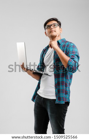 handsome Indian / Asian male student using laptop, isolated on white background
